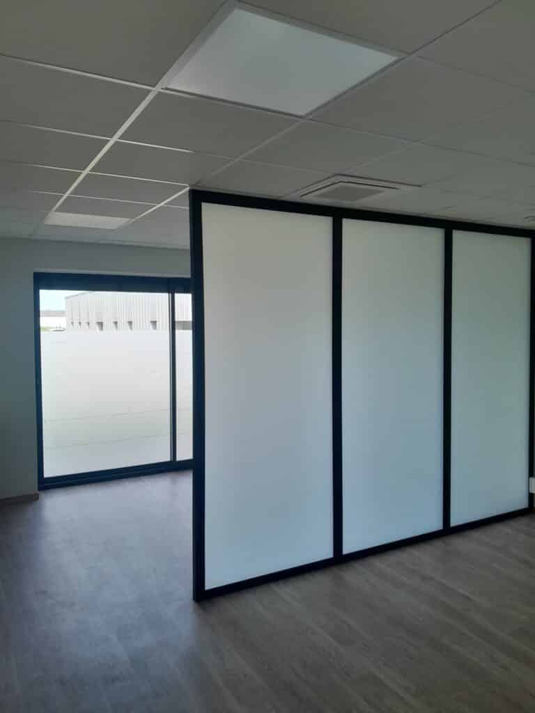 Cloison de Bureau Vitrée Dépolie avec Cadre Noir Design Cloison de bureau vitrée dépolie avec cadre noir et sol aspect bois dans un espace de travail professionnel moderne.